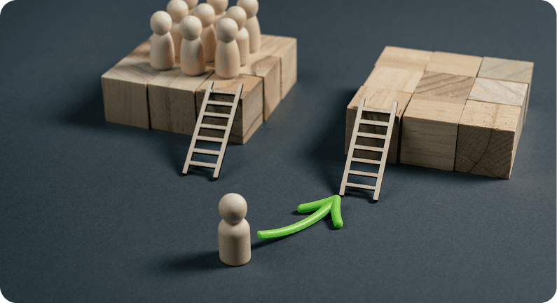 Wooden figures and blocks with ladders, one figure guided by a green arrow towards a ladder